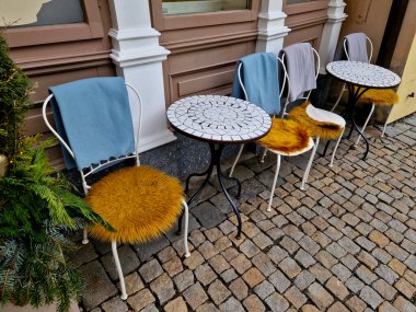 Keçeli kürk bir hayvanın derisine benzer ama plastikten yapılmıştır. Kafenin ön cephesinin ahşap tarihi kaplamasında konuklar için bir battaniye. Mozaikli yuvarlak masa.