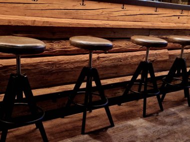 Restoranın karşısındaki eski bir ahırdan kirişler. Daire şeklinde bar tabureleri için deri yastıklı kaplamalar. Paltoların, çantaların, çantaların, çantaların...