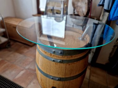 Halkalı eski bir meşe fıçısından yapılmış bir masa. Ayakta duran masa için metal bir mobilya bacağı yapıldı, tabana dairesel cam bir kapak yapıştırıldı. Şarap barı veya bardaki bar masası.