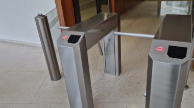 Paslanmaz çelikten yapılmış binanın turnikesi. Bilet gişesinden alınan giriş kartlarına ya da biletlere tepki veriyor. Eğlence merkezi. beyaz döşeme