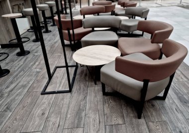 Kafede deri döşemeli yuvarlak şekilli masalar. kahverengi kavisli sandalye