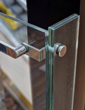 Cam panellerden oluşan lüks bir evin parmaklıkları gri metal paslanmaz çelik panellerle bağlanmış. Sütlü buzlu cam bariyer havadar bir izlenim veriyor. cilalanmış metal kaplama