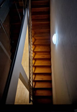 Düz, ahşap panelli merdiven manzarası. Çatı katında mutfak dolabı ışığı olan duvar, paslanmaz çelik.