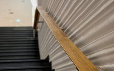 Parlak duvar panelleri ve meşe ağacından yapılmış metal parmaklıklar. Dalgalı sıva ve lüks bir görünüşü var. mermer taş koyu