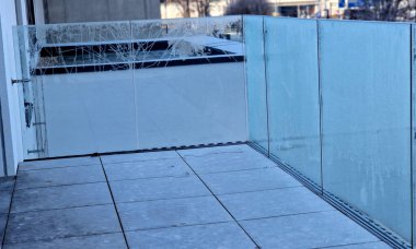 Metal paslanmaz çelik saplarla tutturulmuş cam panellerden oluşan lüks bir evin parmaklıkları. Havalı bir izlenim veriyor. Sera terası penceresinde cilalanmış metal kaplama, yansıma, iki, yapıştırıcı.