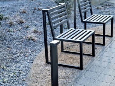 İki sandalye, metal, çizgili, gölgesi beni kaldırımın kenarındaki bir park bankının dış hatlarındaki buzdan koruyan bir bank..