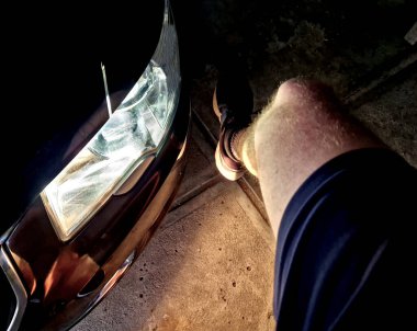 Bir arabanın önünde yerde yatan bir adam. Aracın ışıkları kaputa düşen koşucuyu kör etmiş. Yoldaki sürücülerin saldırganlığı. Sporcu şortla yerde yatıyordu.