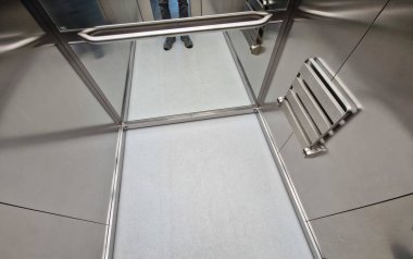 Paslanmaz çelik asansör kabini, sert meşe zeminli ve ayna panelli. Lüks ofislerde, odunlarda, odunlarda ve odunlarda yaşlılar için tırabzanlar ve yaslanan koltuklar