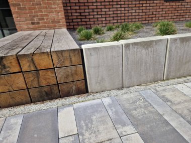 Eski kulübedeki tuğla teras yeşil çimenlik ve doğal alçı duvarla devam ediyor. Tuğlalar çimento kullanılmadan döşenmiş. Meşe kirişlerinden yapılmış bank kafede bir kanepe görevi görüyor..