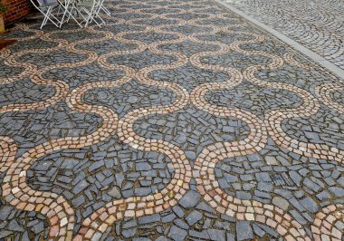 ripples pattern from mosaic cubes on black rough pavement. squares and dashed lines. promenade in the square with repeating lines of the shape of waves and hearts clipart