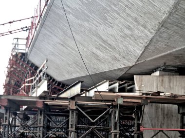 İnşaat alanındaki iskeleler ve destekler köprü kemerlerini tutuyor. Temellerdeki metal sütunları vidalayın. Profesyonel şirketler yıllarca garanti veriyor.