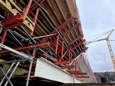 İnşaat alanındaki iskeleler ve destekler köprü kemerlerini tutuyor. Temellerdeki metal sütunları vidalayın. Profesyonel şirketler yıllarca garanti veriyor.
