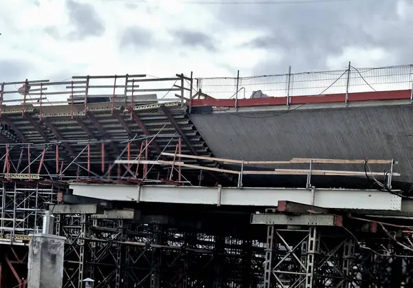 İnşaat alanındaki iskeleler ve destekler köprü kemerlerini tutuyor. Temellerdeki metal sütunları vidalayın. Profesyonel şirketler yıllarca garanti veriyor.