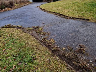 Bahçıvan çimlerin kenarlarını çimenliğin kenarlarından buduyor. Çuvallar ve kir gübreleme tesisine gidecek.