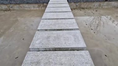 Metal destekli su birikintilerindeki taş geçitler donmuş suyun üzerindeki taş levhaları havaya kaldırıyor. Bir gölet resmi veya Japon bahçesindeki bahçe yolu. dikdörtgen mermer levhalar, cilalanmış