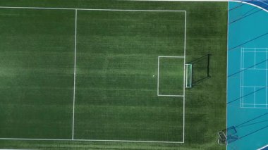 Birkaç şeritli koşu pisti olan bir spor stadyumu. Oval Ofis 'te netbol ve hentbol için kalkan engelleri olan küçük bir futbol sahası var. Sentetik bölge. Yukarıdan manzara, tüm hava koşulları, kauçuk, 