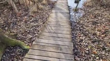 Tahta kalaslardan, rıhtımdan, göl suyunun dibine kadar uzanan cambaz ayaklıklarının üzerindeki dar kıvrımlı patikalardan oluşan yüzen yürüyüş yolu. Korkulukları yok. Tekerlekli sandalyeler için daha çok korkuluklu kaldırım