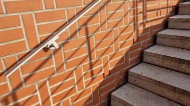 Merdivenler ve açık tuğla parmaklıklar pürüzsüz yüzey. U şeklindeki tuğla istinat duvarlarının köşelerindeki metal korkuluklar ve banklar. Aralıklı ışıklar yayaların ayaklarının altını aydınlatıyor.