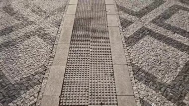 Siyah asfalttaki mozaik küplerin dalgalanma izleri. Kare ve kesik çizgiler. Meydanda dalgaların ve kalplerin tekrar eden çizgileriyle dolaş.