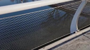 Köprü parmaklıklarına gerilmiş paslanmaz çelik ağ. Alt çelik halat su kanalına bariyer görevi görüyor. Tekerlekli sandalye kullanıcısı çökmek zorunda değil, bisiklet yan taraftaki bir kablo tarafından yönlendirilir, patika, yol işaretleme