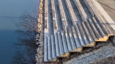 Gemileri demirlemek için yüzen iskele menteşeli metal çubuklarla sabitlenir. Ahşap merdivenler nehirdeki suyu gözlemlemek için kullanılır, Iris.