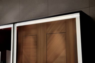 Aynayı ışık çubuğuyla çerçevelemek. Arkadaki ışık, lavabodaki kişiyi aydınlatır. Bir otel banyosundaki çok dekoratif basit tuvalet malzemeleri dolabı.