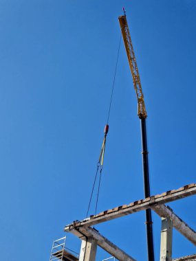 Binanın beton sütunlarını bir vinç kullanarak parça parça sökün. Ezici maşa makinesine zincir hareketinde askıya alınmış. Güvenliği sağlamak için yüksek katlı bir binanın betonunu kesin.