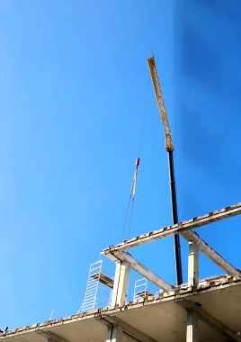 Binanın beton sütunlarını bir vinç kullanarak parça parça sökün. Ezici maşa makinesine zincir hareketinde askıya alınmış. Güvenliği sağlamak için yüksek katlı bir binanın betonunu kesin.