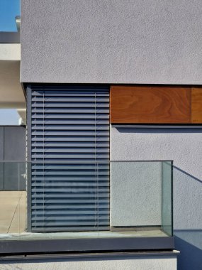 Metal paslanmaz çelik saplarla tutturulmuş cam panellerden oluşan lüks bir evin parmaklıkları. Havalı bir izlenim veriyor. Sera terası penceresinde cilalanmış metal kaplama, yansıma.