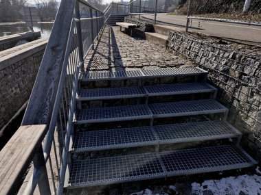 Endüstri salonu, deponun yüksek dirençli dik bir merdiveni var. Ağır galvanize çelik zemin ızgara ve parmaklıkların altında bile. Genişletilmiş metal, güvenlik merdivenleri, siyah, delinmiş