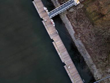Beton zeminde metal çubukların yanında yüzen beton iskele var. Zincirler ve halatlar sel ihtimaline karşı sigorta olarak. Tahta paneller ve parmaklıklar gibi kalın örgüler.