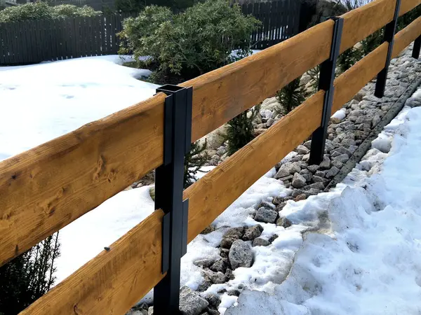 Ahşap bir çit, her zaman yeşil olan çalılarla birleşince kır evindeki bir bahçeyi çitlemek için doğal bir çözüm.