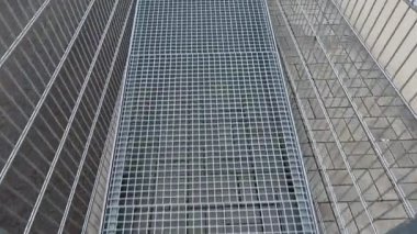 Yerde metal parmaklıklar ve metal parmaklıklar var. Merdiven yerine tekerlekli sandalye kullanıcıları için bir rampa, bir ağ, galvanizli malzeme var. Tekerlekli sandalye. konut binası, hastane girişi, kıdemli, 
