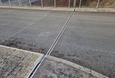 İki genişletilebilir beton gövdenin güvenli bağlantısı için çatı yapısı veya köprü genişlemesi. Metal bir barda lastik eklem, genişletilebilir beton cisimler. Motorun eklemlerini genişletmek için paslanmaz çelik tarak