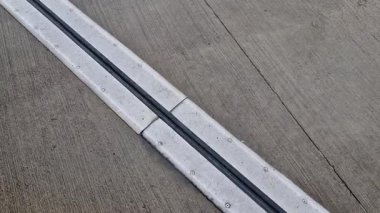 İki genişletilebilir beton gövdenin güvenli bağlantısı için çatı yapısı veya köprü genişlemesi. Metal bardaki kauçuk eklem, sıcaklığın bozulmasını önleyen binalarda yapısal değişiklikler, vida