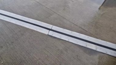 İki genişletilebilir beton gövdenin güvenli bağlantısı için çatı yapısı veya köprü genişlemesi. Metal bardaki kauçuk eklem, sıcaklığın bozulmasını önleyen binalarda yapısal değişiklikler, vida