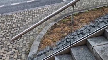 Cam, camı delmek için tasarlanmış vida ve çamaşır makineleriyle duvara tutturulmuş. Kaplama bir tırabzan ve hava bölümüdür. İstasyon, sokak, lüks.