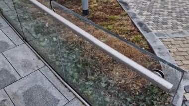 Cam, camı delmek için tasarlanmış vida ve çamaşır makineleriyle duvara tutturulmuş. Kaplama bir tırabzan ve hava bölümüdür. İstasyon, sokak, lüks.