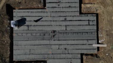Yan yana yapılmış siyah asfalt karton rulo. Çatı ve ev yalıtıcıları için depo. Temiz bir giriş için propan gazı ile kaynak yapıyorlar.
