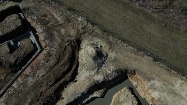 Beton bir temel levhası. Tuğla ustaları üstüne tuğla bloklar inşa eder ve bir zemin inşa ederler. Beton kaplamalı muşambalarla kaplı. Beton bir pompa karışımından beton döküyor.