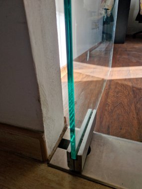 Modern bir mağazanın duvarları ve kapıları camdan yapılmış butikler. Menteşeler bir menteşeyle tutunur. Çerçevesiz. Daha aydınlık ve ferah, pankart var. İçerde, içeride.