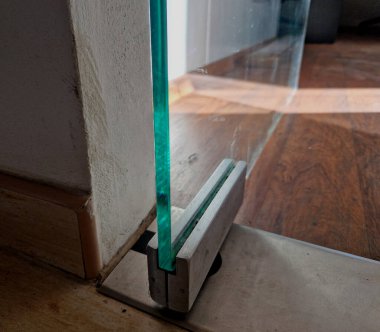 Modern bir mağazanın duvarları ve kapıları camdan yapılmış butikler. Menteşeler bir menteşeyle tutunur. Çerçevesiz. Daha aydınlık ve ferah, pankart var. İçerde, içeride.
