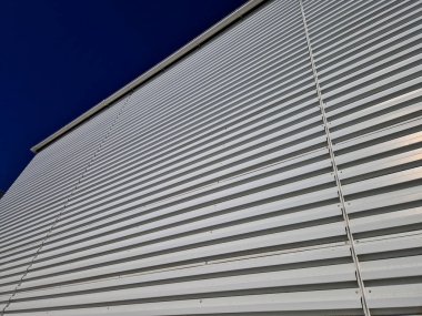 Ön cephesinde metal levha olan metal bir garaj. Dik yatay şeritli lojistik salonu. Dayanıklı ve bakımsız yüzeyler fabrika deposu, otomobil endüstrisi