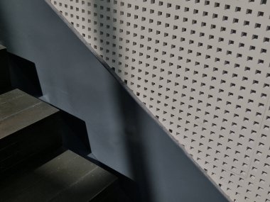 Delikli alçı kaplama tavan panelleri fayanslı zemini olan büyük bir salonda yankılanıyor. Seslerin boğuk, baskının, ses sisteminin, ahşap zeminin duyulduğu bir otele giriş salonu.