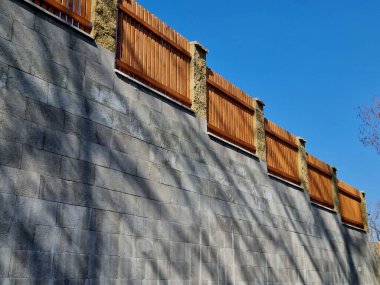 Doğal tahtalardan yapılmış ahşap çitler. Sütunlar kabaca beyaz sütunlardan oluşmuştur. Yatay yerleştirilmiş tahtalardan yapılmış tam çit. Karaya bitişik bir çalılık yatak var.