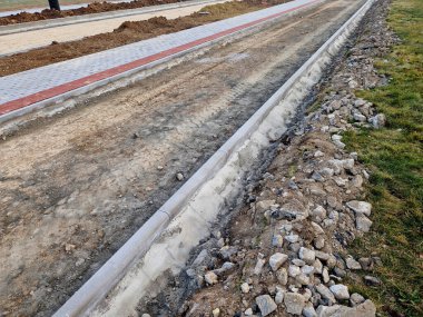Beton kaldırımın betona dönüştürülmesi. Şu ana kadar asfalt katmanı döşemeden ve yuvarlanmadan önce sadece beton tabanı olan yol boşluğunda..