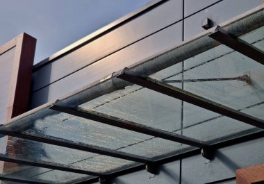 strut, suspended glass roof above the building entrance. bus station, railway station. cable wind braces. aluminum construction with windows above the pergola