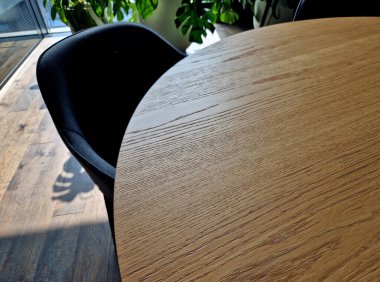 Yuvarlak masalı toplantı odası ve tropik ahşap kaplamalı derin oyuklar. Hoş yayılmış ışık ve kapalı alan bitkileri