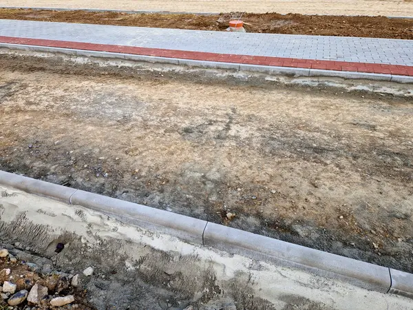 Beton kaldırımın betona dönüştürülmesi. Şu ana kadar asfalt katmanı döşemeden ve yuvarlanmadan önce sadece beton tabanı olan yol boşluğunda..