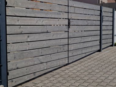 Bahçeye açılan kapı. Çalışan bir dişlisi var ve bir dişli tekerlek geri çekilir ve uzaktan kumandadaki talimatlara göre kapı yaprağını genişletir.